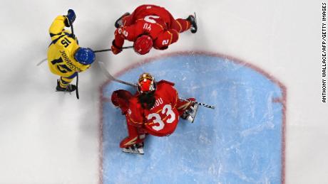 China&#39;s goaltender Zhou Jiaying (bottom) and teammate Yu Baiwei defend their goal from Sweden&#39;s Lisa Johansson during their women&#39;s preliminary round group B match at the Beijing 2022 Winter Olympic Games.