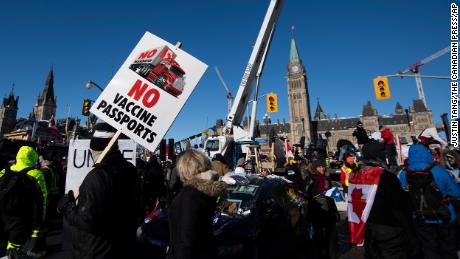 People hold signs and wave flags along Wellington Street in front of Parliament Hill on February 5 as part of the Freedom Convoy protest.