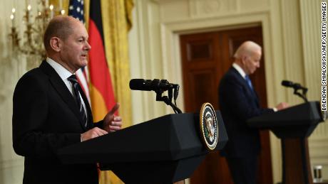 US President Joe Biden (R) listens as German Chancellor Olaf Scholz speaks during a joint press conference in the East Room of the White House in Washington, DC, on February 7, 2022. 