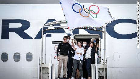 Der Präsident des Organisationskomitees von Paris 2024, Tony Estanguet (L), und die Bürgermeisterin von Paris, Anne Hidalgo (C), schwenken die olympische Flagge, um die Übergabe zu markieren.