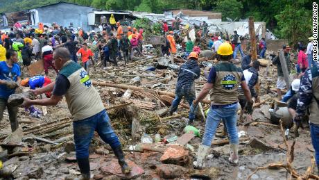 Neighbors join rescue workers in the hunt for survivors after a rain-weakened hillside collapsed over homes in Pereira, Colombia, on Tuesday.