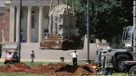 A construction crew in 2020 lifts the stone that once held the Confederate memorial plaque that bore the names of cadets from the University of Alabama who deployed to defend the school during the Civil War.