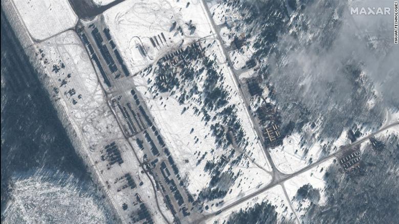 Maxar&#39;s satellite images show what they called a &quot;new deployment of troops, military vehicles and helicopters&quot; at the Zyabrovka airfield in Belarus.
