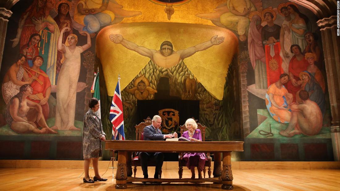 Charles and Camilla sign the visitor&#39;s book in front of a Diego Rivera mural while visiting Mexico City in November 2014.