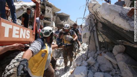 Members of the Syrian civil defence, known as the White Helmets, pull out a child from under the rubble following a reported Russian air strike on Maaret al-Numan in Syria&#39;s Idlib province in 2019. 