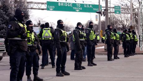 Polisi berbaris di Windsor pada Sabtu pagi dalam persiapan untuk menegakkan perintah terhadap demonstrasi di dekat Jembatan Duta Besar.