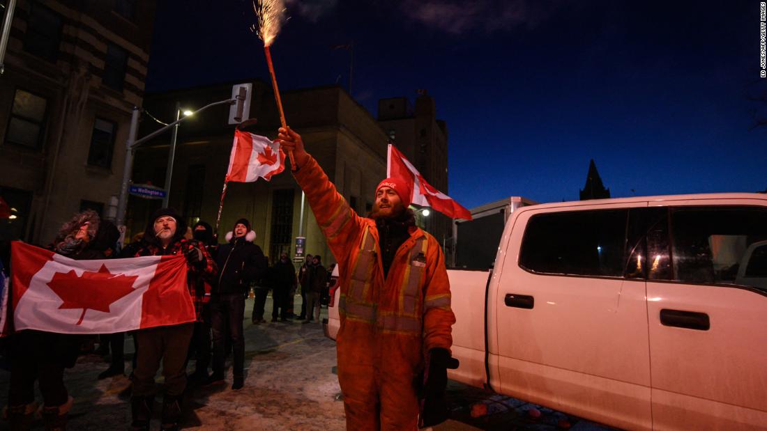 A demonstrator lets off a firework during a protest outside Parliament in Ottawa on February 12.