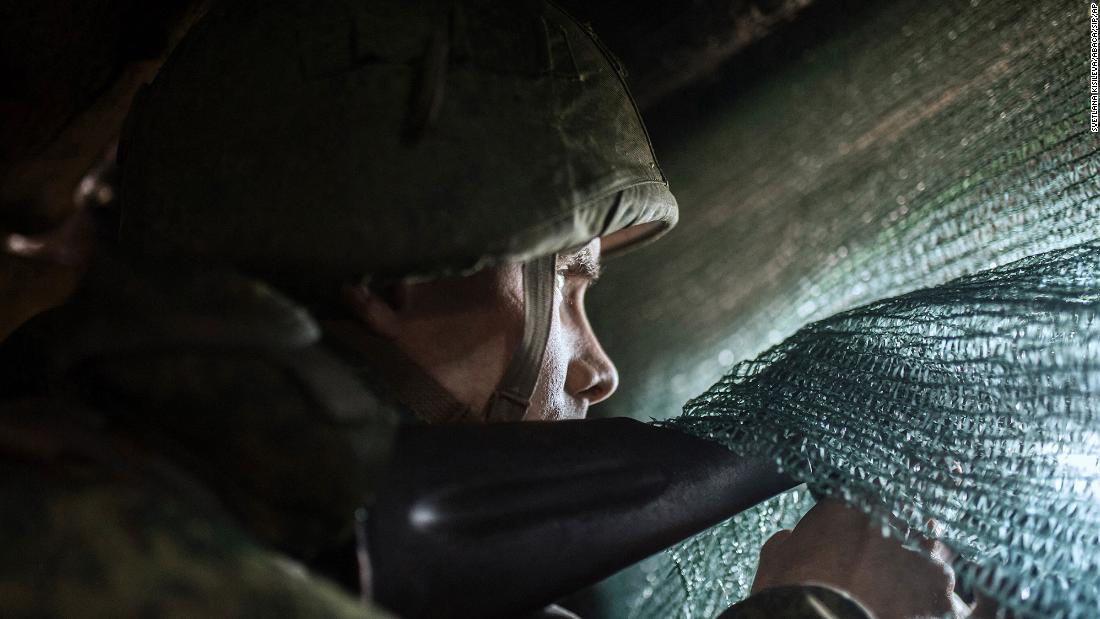 Pro-Russian separatists observe the movement of Ukrainian troops from trenches in Ukraine&#39;s Donbas area on February 11.