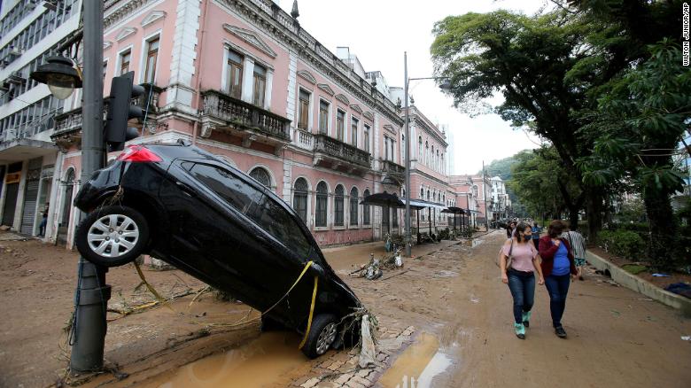 Flood waters swept cars through the city streets.