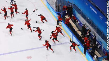 Canada&#39;s players rush onto the ice in celebration after beating Team USA in the women&#39;s ice hockey gold medal match.