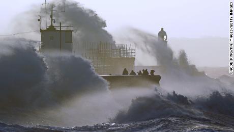 Des vagues se sont écrasées sur la digue et le phare de Porthcaule à Bridgend, au Pays de Galles, alors que la tempête Eunice a frappé le Royaume-Uni vendredi. 