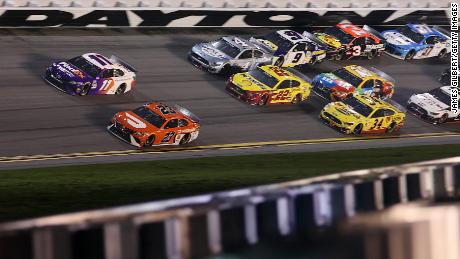 Bubba Wallace, driver of the #23 DoorDash Toyota, and Denny Hamlin, driver of the #11 FedEx Toyota, lead the field during the Daytona 500 in 2021.