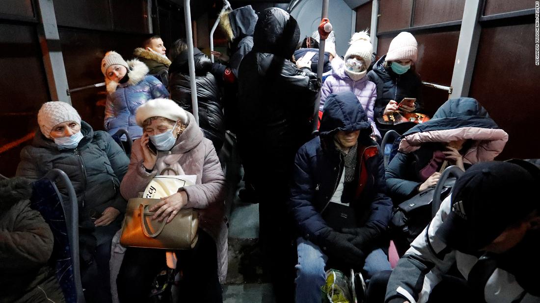 People sit on a bus in Donetsk in eastern Ukraine on Friday, February 18, after they were ordered to evacuate to Russia by pro-Russian separatists.
