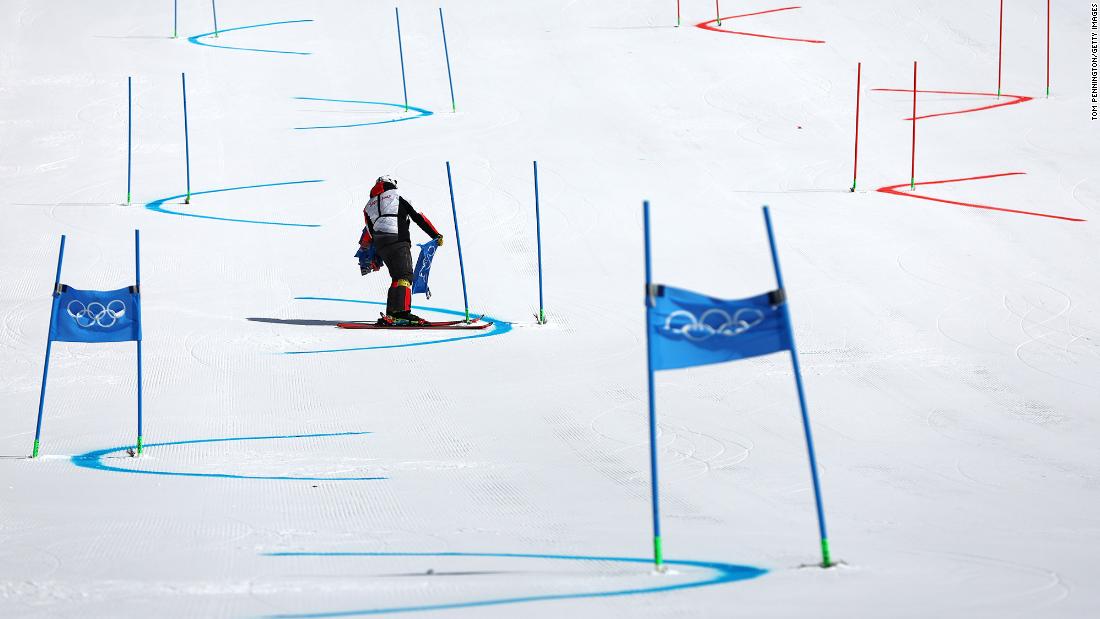 A course worker removes gate flags after the alpine skiing mixed team event was &lt;a href=&quot;https://www.cnn.com/world/live-news/beijing-winter-olympics-02-19-22-spt/h_898007b8fba0b1cf63ca478972584e50&quot; target=&quot;_blank&quot;&gt;postponed due to poor weather conditions&lt;/a&gt; on February 19.