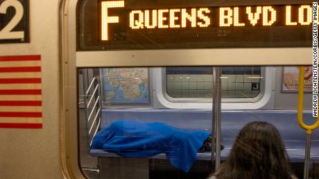 A homeless man sleeps on an F train subway in Brooklyn, New York. 
