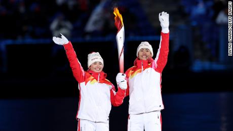 Torch bearers Dinigeer Yilamujiang and Jiawen Zhao of Team China hold the Olympic flame during the opening ceremony on February 4.