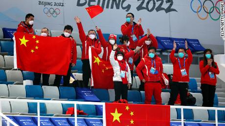 Spectators cheer for Team China during a curling match the Beijing 2022 Winter Olympics.