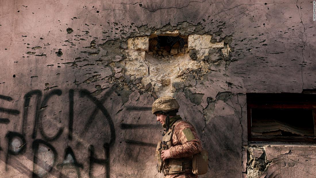 A Ukrainian service member walks by a building on February 19 that was hit by mortar fire in the front-line village of Krymske, Ukraine.