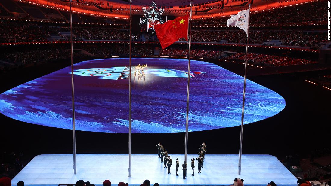 The flags of China and the International Olympic Committee are raised at the start of the closing ceremony.