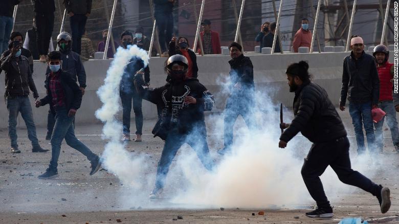 A demonstrator hurls back a tear gas towards the police during a protest in Kathmandu, Nepal, on February 20.