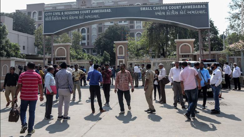 People await a verdict outside the City Civil And Sessions Court in Ahmedabad, India, on February 18.