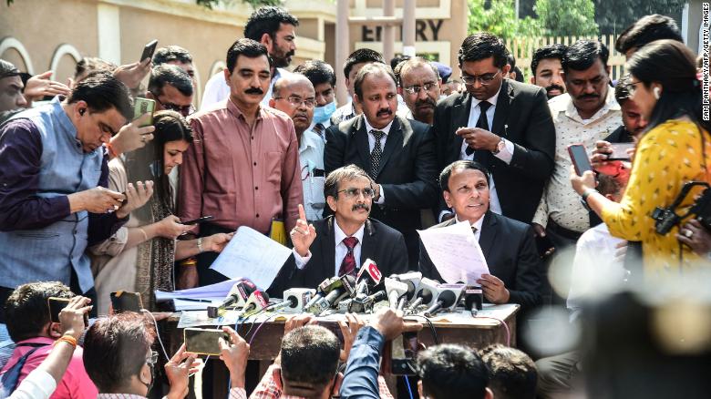 Public prosecutors A.R. Patel (center left) and Sudhir Brahmbhatt (center right) speak to reporters outside the Sessions Court in Ahmedabad, India on February 18.