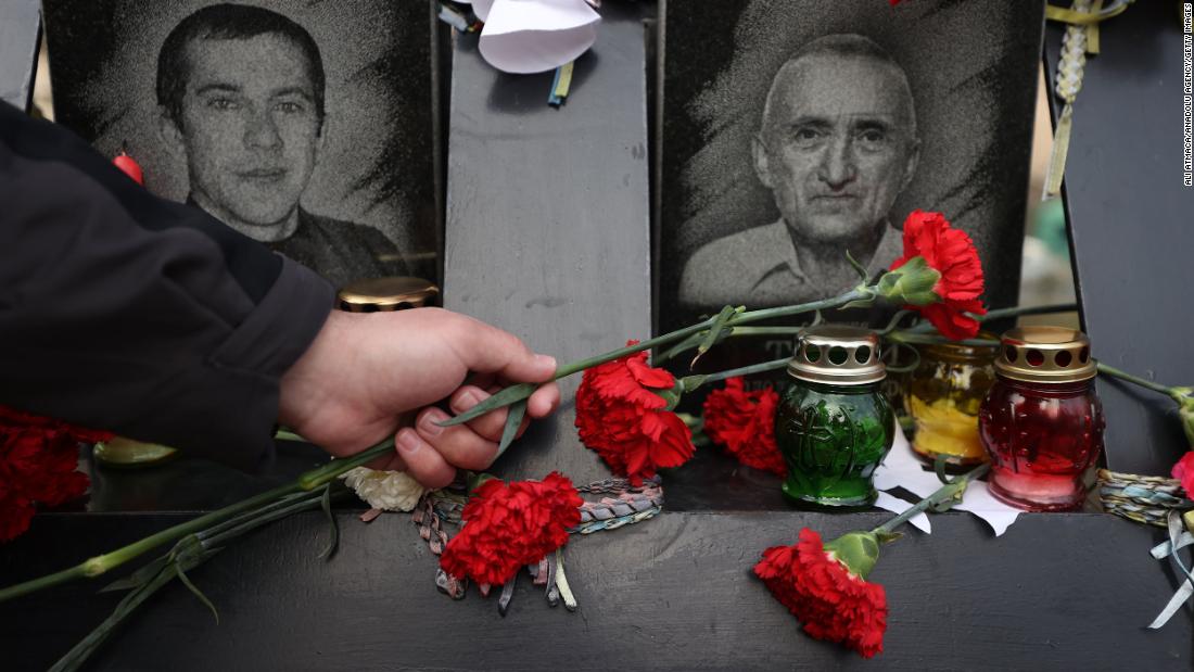 People lay flowers at the Motherland Monument in Kyiv on February 21.