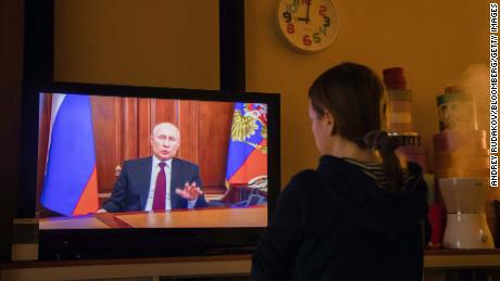 A resident watches a live broadcast of Russian President Vladimir Putin on Monday, Feb.  22.