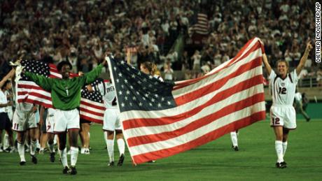 Las integrantes del equipo olímpico femenino de fútbol de EE. UU. sostienen la bandera de EE. UU. en el campo el jueves 1 de agosto de 1996 después de la victoria del equipo por 2-1 sobre China por la medalla de oro.  (Prensa asociada/Death Indler)