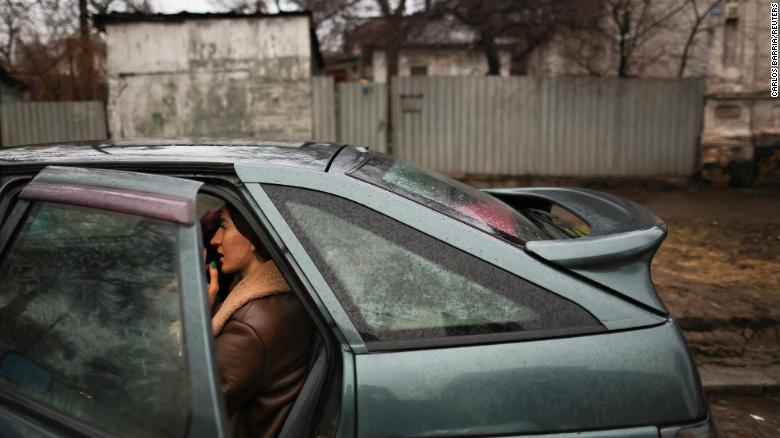 A local resident sits in a car as they pack to leave Mariupol, eastern Ukraine.