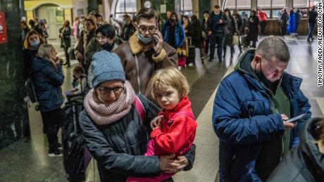 People wait in line to buy train tickets at the central train station in Kyiv.