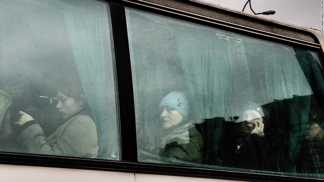 People wait on a bus leaving Kyiv on February 24.