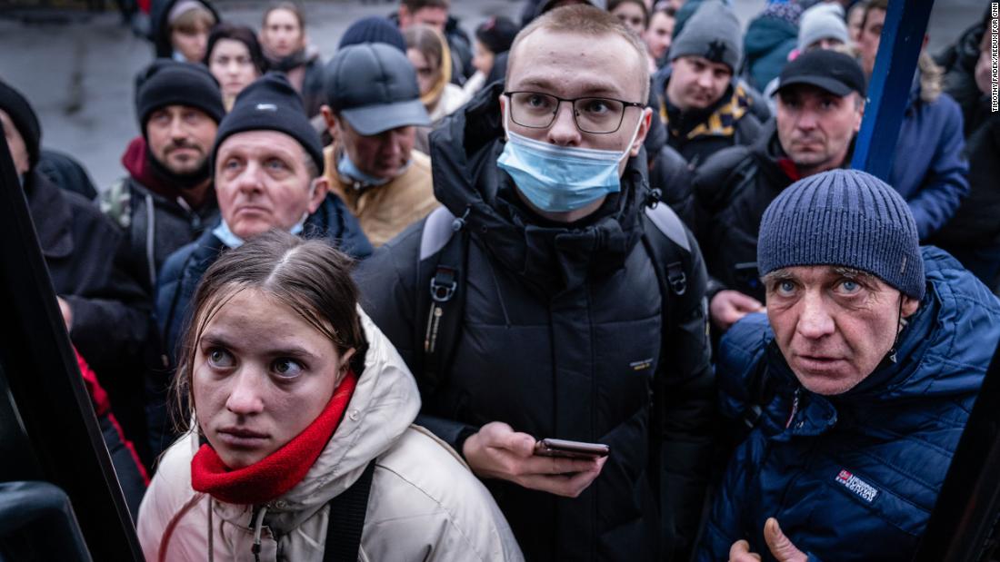 People in Kyiv try to board a bus to travel west toward Poland on February 24.