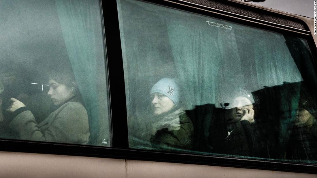 People wait after boarding a bus to leave Kyiv on February 24.