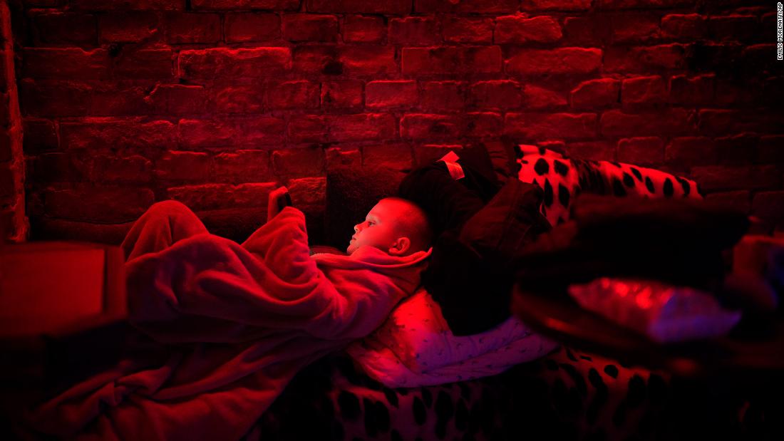 A boy plays with his tablet in a public basement used as a bomb shelter in Kyiv on February 24.