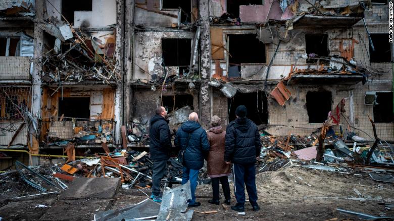 Oamenii se uită la pagubele în urma unui atac asupra orașului Kiev, 25 februarie.
