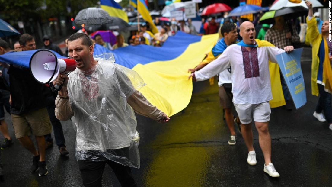 People carry a Ukrainian flag during a protest in Sydney on February 26.