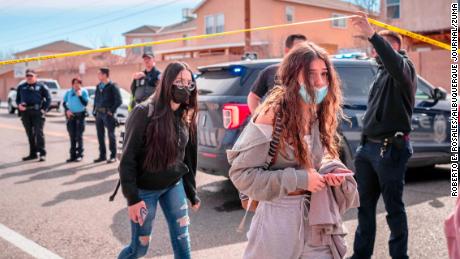 Police and students are seen after a fatal shooting near an Albuquerque high school Friday.