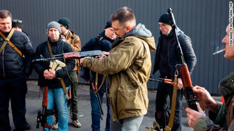 Members of Ukraine&#39;s Territorial Defense Force in Kyiv prep their weapons to defend themselves against Russian forces on February 26. 