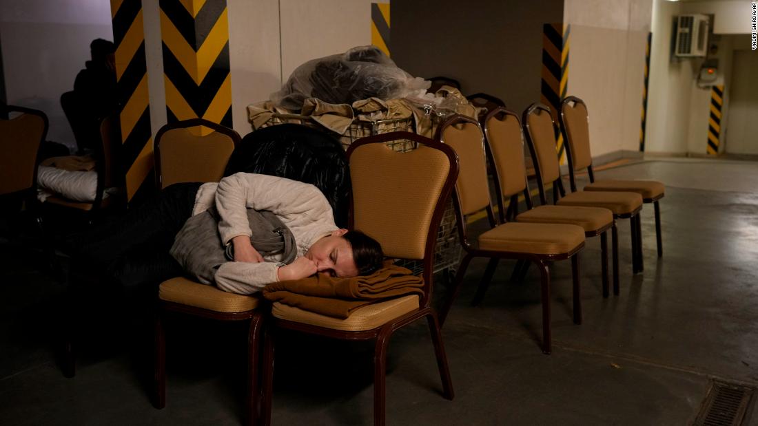 A woman sleeps on chairs February 27 in the underground parking lot of a Kyiv hotel that has been turned into a bomb shelter.