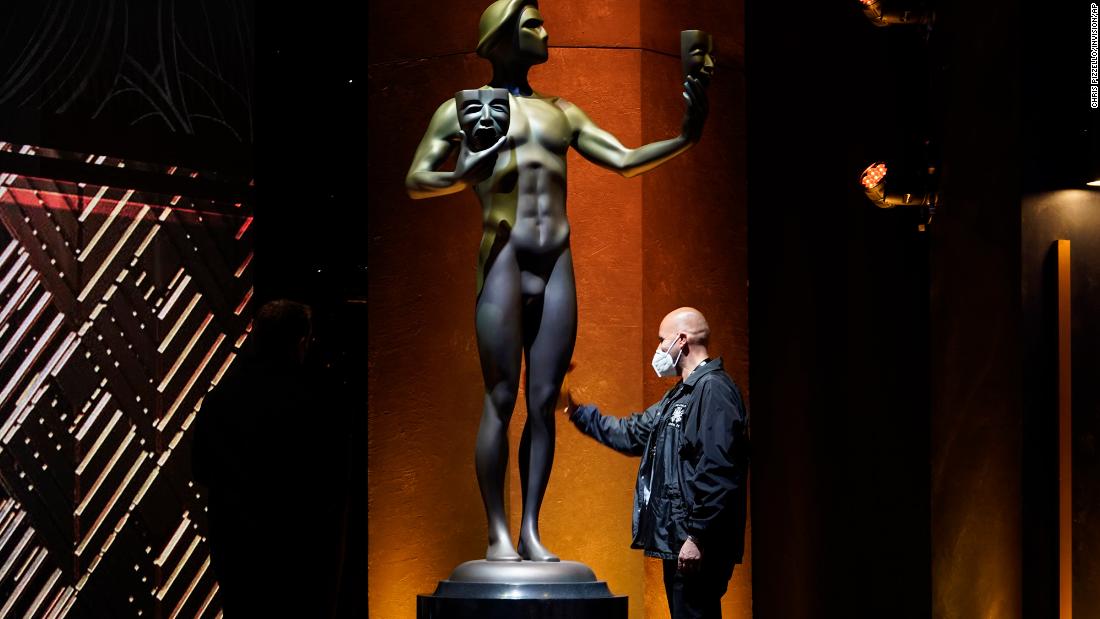 A worker cleans off a giant SAG award statue prior to the show.