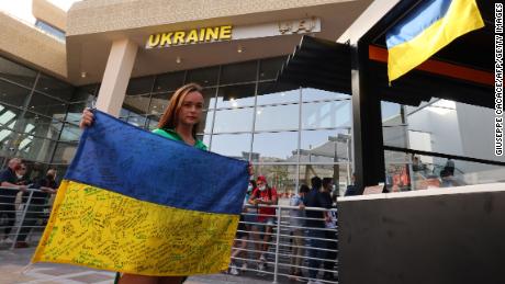A woman poses for a picture with a signed Ukranian flag at the Ukraine pavillion at Expo 2020 in Dubai, on February 27.