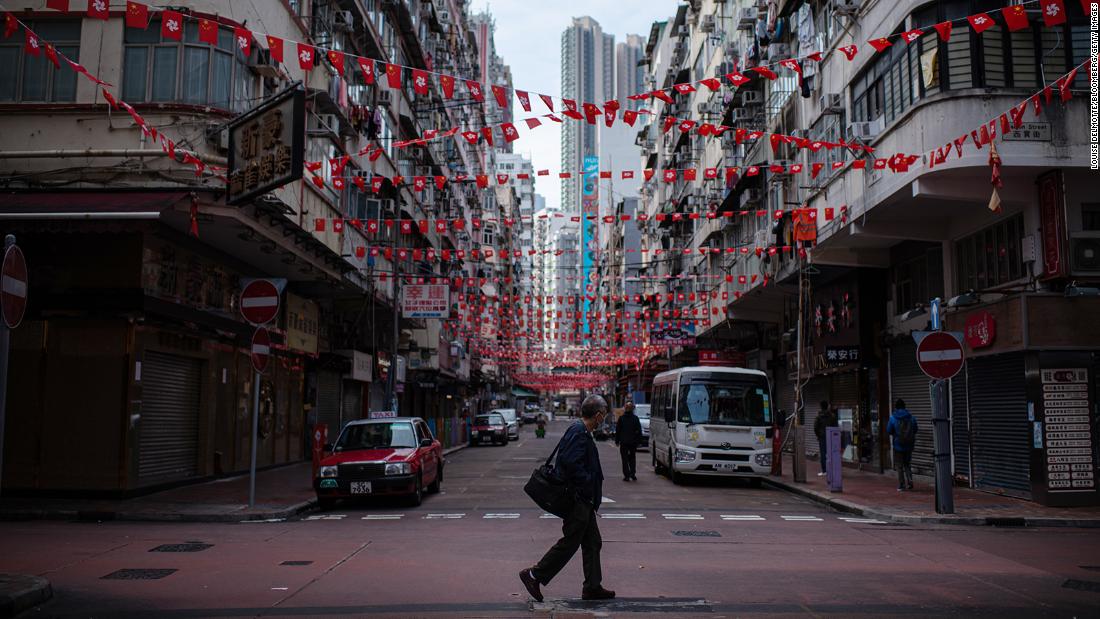 A pedestrian crosses a near empty street in Hong Kong on February 24, 2022.
