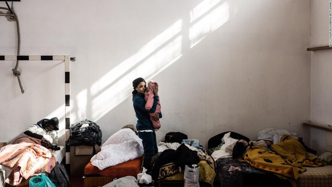 A displaced Ukrainian cradles her child at a temporary shelter set up inside a gymnasium in Beregsurány, Hungary, on February 28.