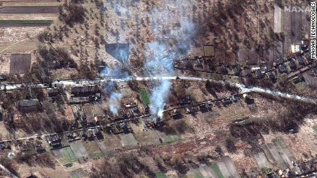 A Russian convoy is seen with smoke billowing from burning houses, northwest of Invankiv, Ukraine.