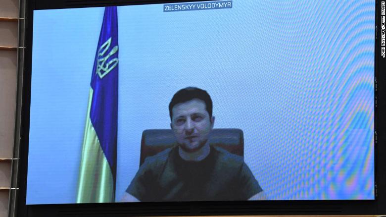 Ukrainian President Volodymyr Zelensky appears on a screen as he speaks in a video conference. 