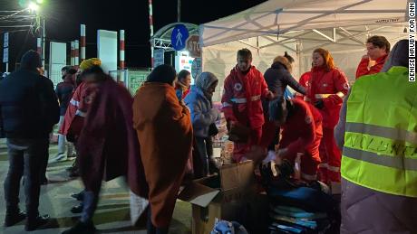 Romanian Red Cross workers hand out blankets to refugees from Ukraine who crossed the border at Sighetu Marmatiei, Romania, shortly before midnight on February 28.
