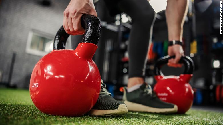 A person uses kettlebells for a strengthening exercise.