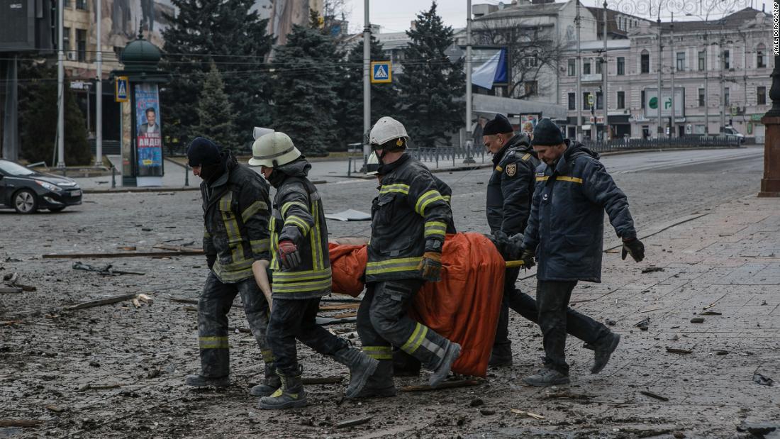 Ukrainian emergency workers carry a body of a victim following shelling that hit the City Hall building in Kharkiv on March 1.