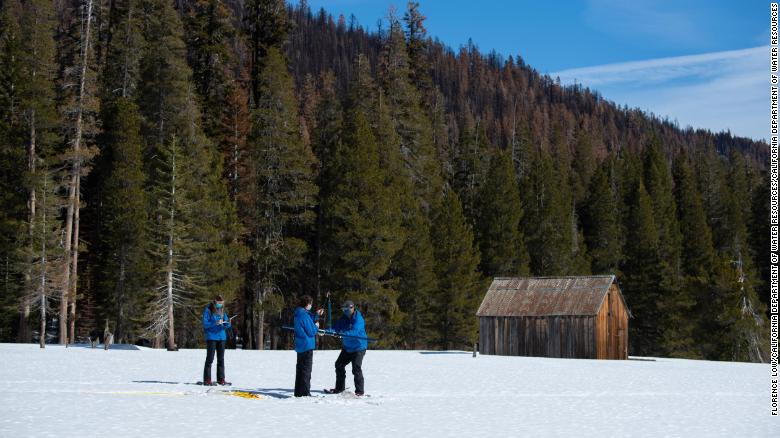 Members of the California Department of Water Resources measure snow totals in the Sierra Nevadas.